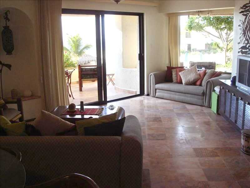Cabo Condo living room opens to patio overlooking Pool & Beach. 
